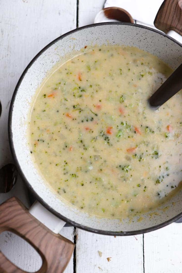 a pot filled with soup sitting on top of a wooden table