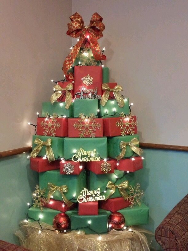 a christmas tree made out of boxes with presents on top and lights around the base