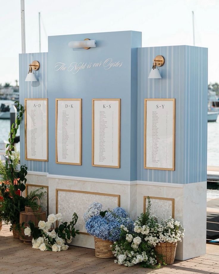 flowers are placed on the side of a blue wall with seating options for people to sit down