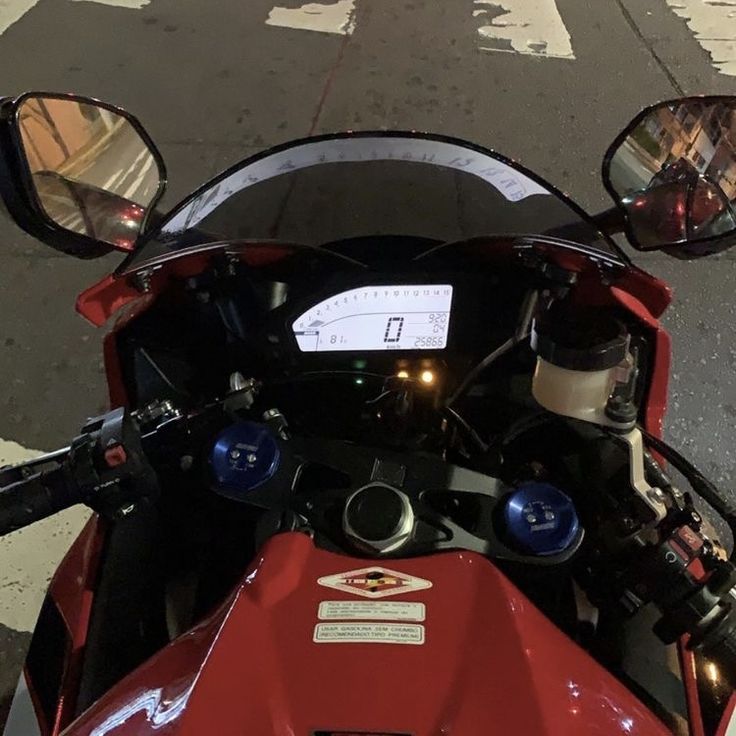 a red motorcycle parked next to a street