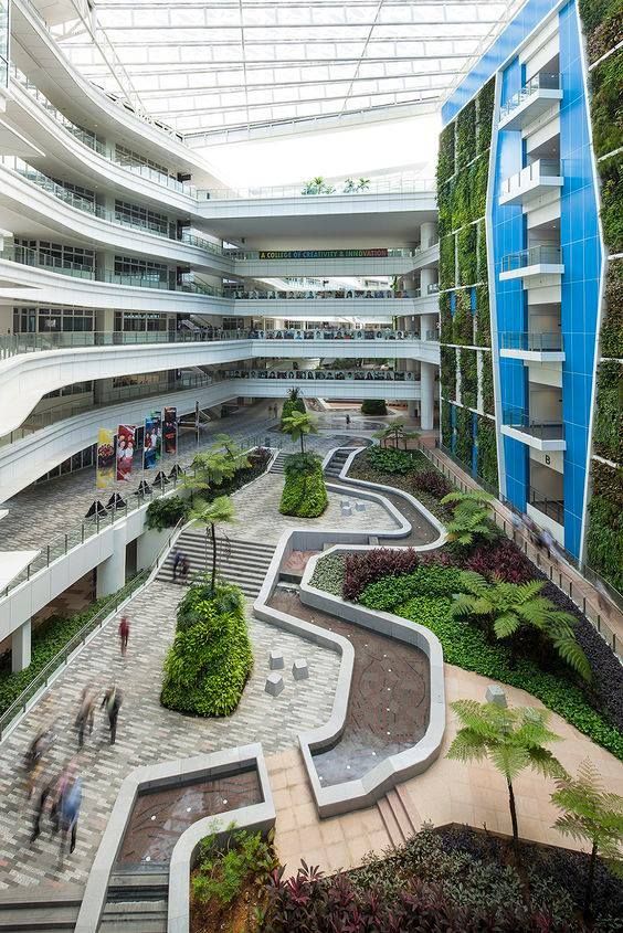 the interior of an office building with plants growing on the walls and stairs leading up to the second floor