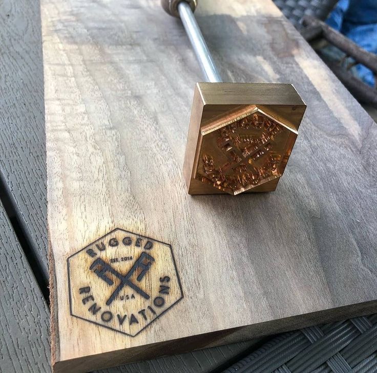 a piece of wood sitting on top of a wooden table next to a metal object