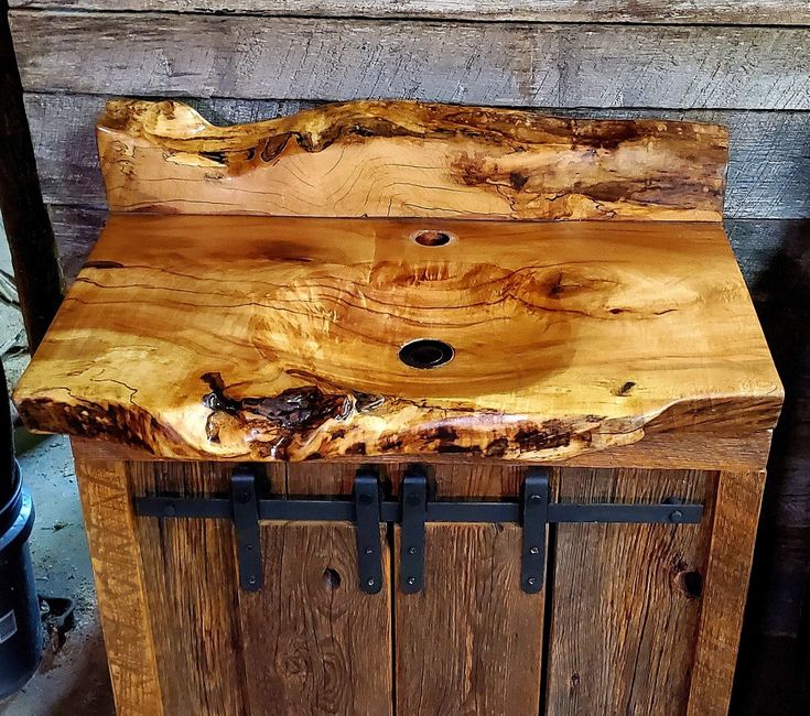 a wooden cabinet with metal handles on the front and sides, made out of wood