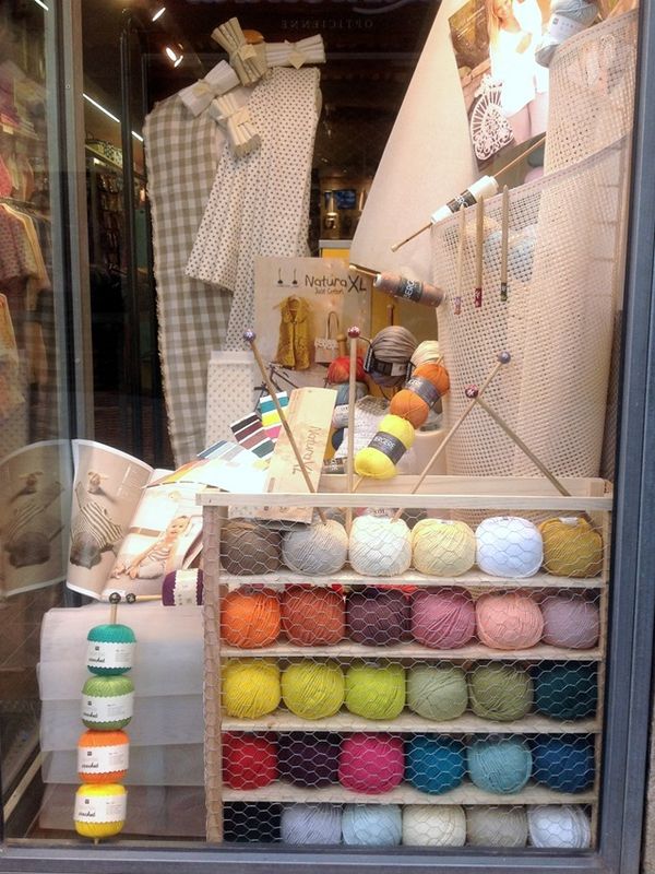 yarn and crochet supplies are displayed in a shop window