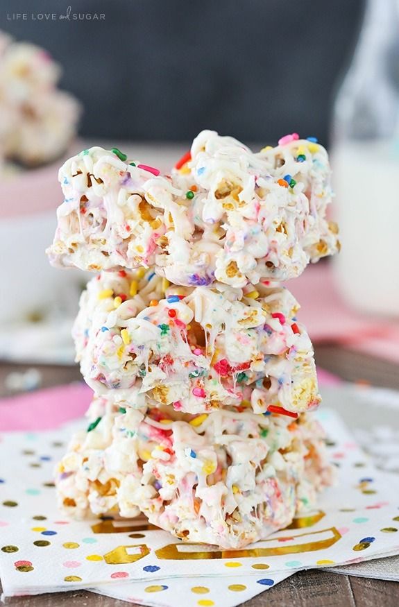 a stack of sprinkle covered cookies sitting on top of a table