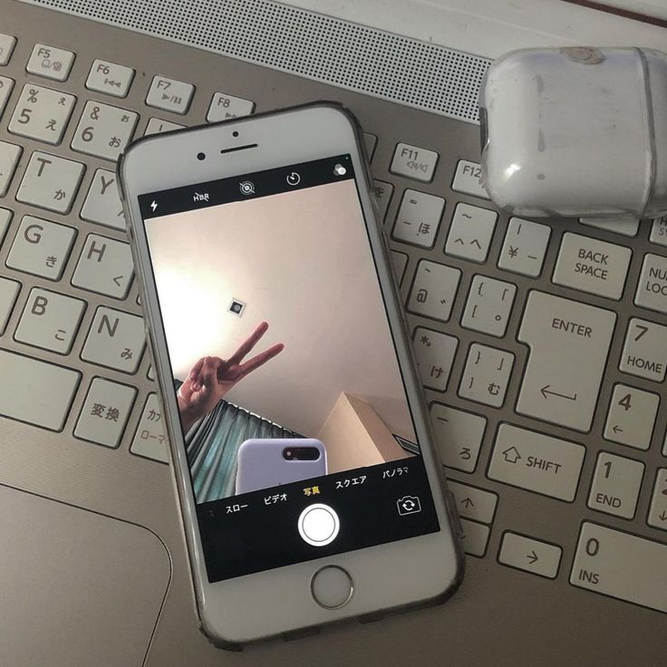 a cell phone sitting on top of a computer keyboard