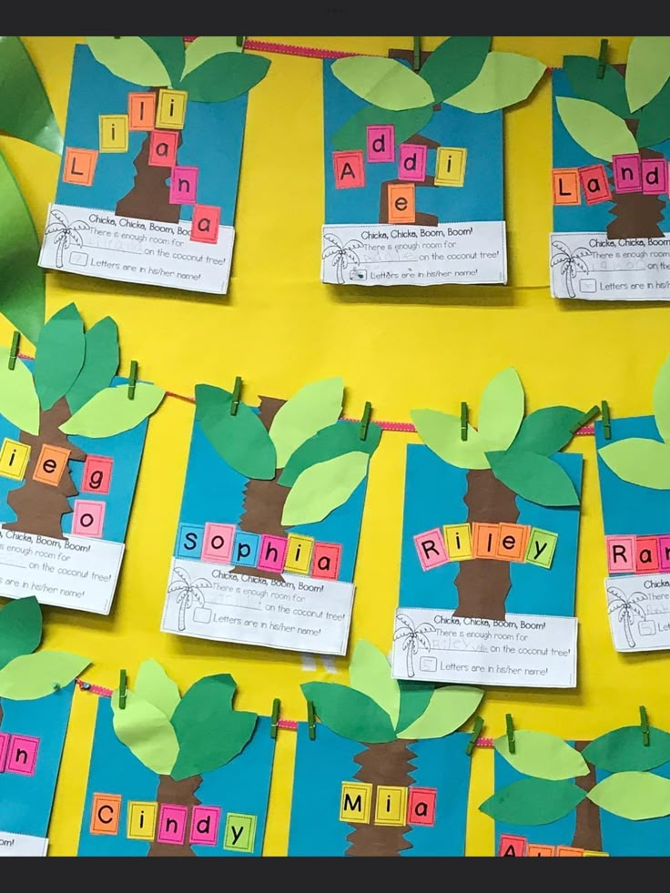 a bulletin board with trees and name tags attached to the boards that spell out words