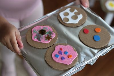 a person holding a tray with decorated cookies on it