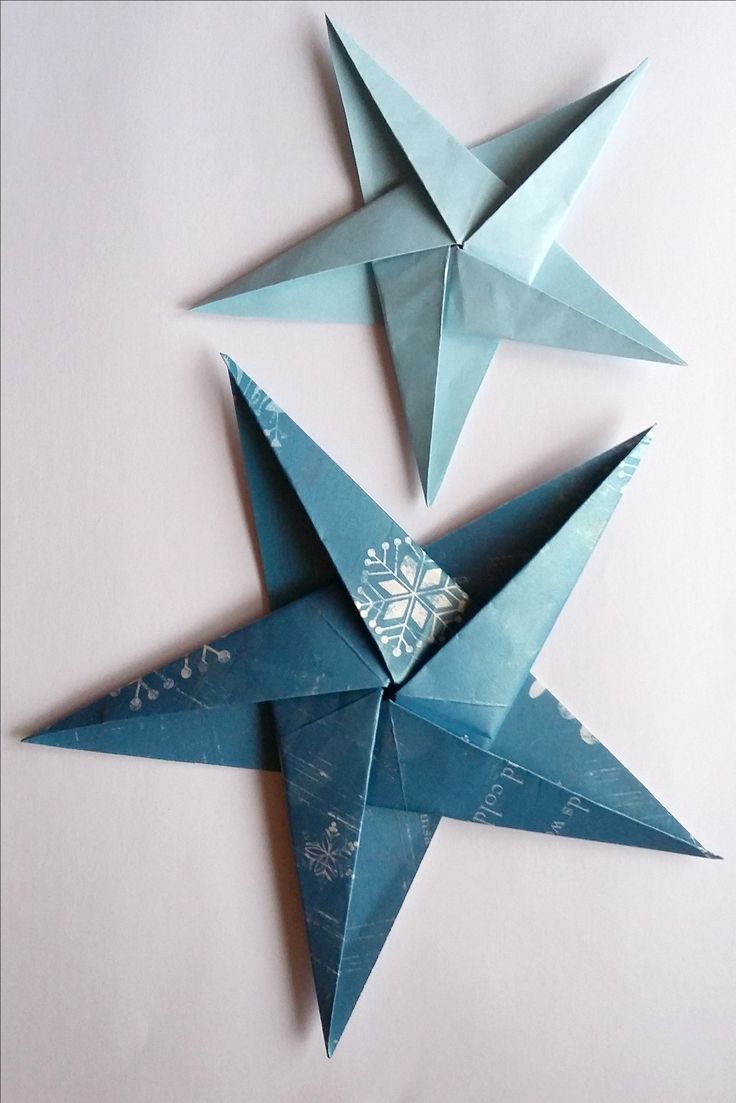 three blue origami stars on a white background