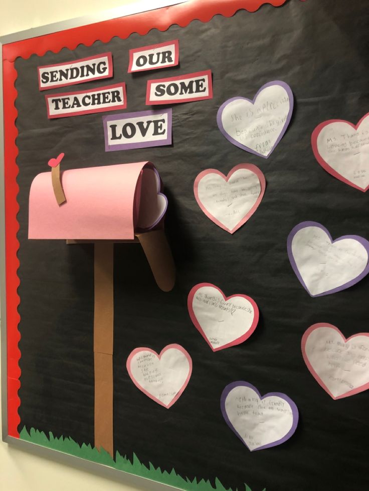 a bulletin board with lots of paper hearts and a mailbox attached to the wall