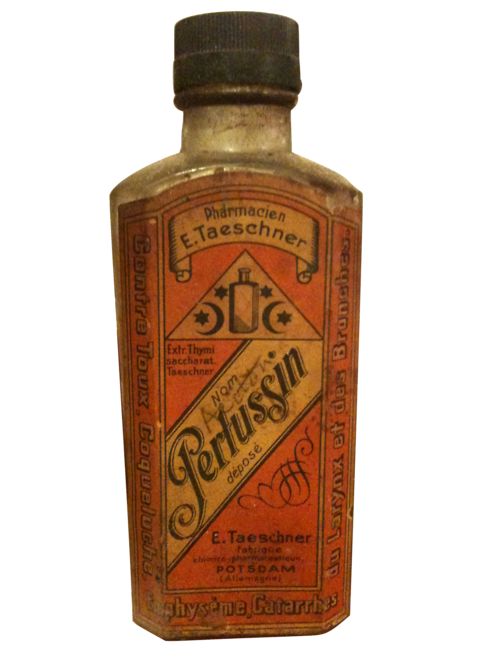 an old fashioned medicine bottle sitting on top of a white surface with writing on it