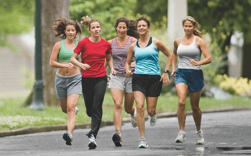 four women are running down the street together