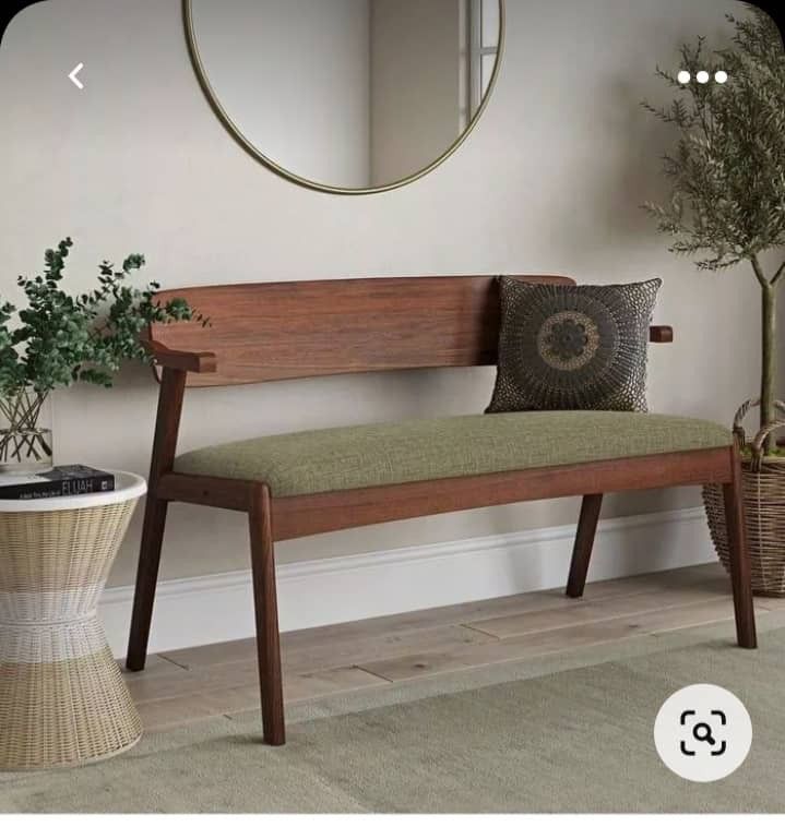 a wooden bench sitting in front of a mirror next to a plant and potted plant