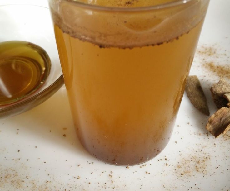 a glass filled with liquid sitting on top of a white plate