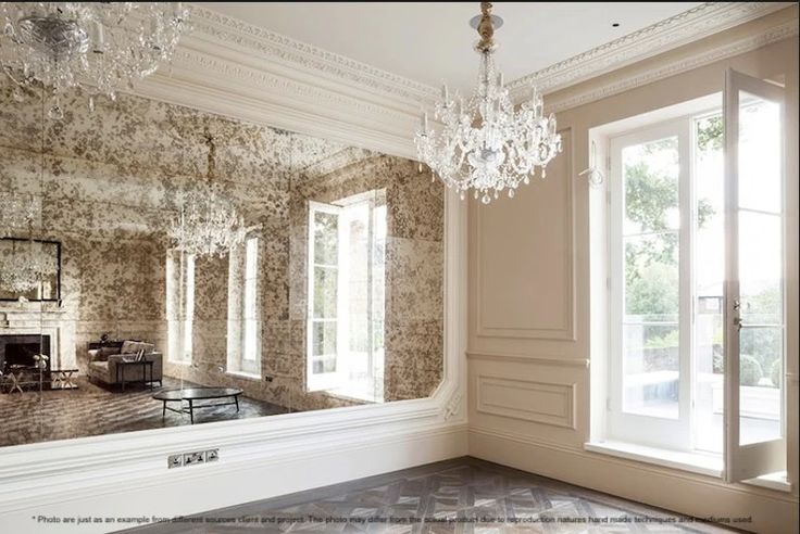 an empty room with chandelier and large windows