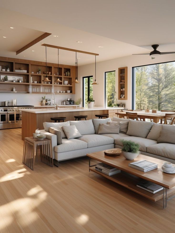 a living room filled with furniture next to a kitchen and dining room table on top of a hard wood floor