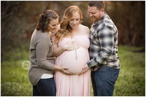 a pregnant woman and two young men standing next to each other with their belly wrapped around her