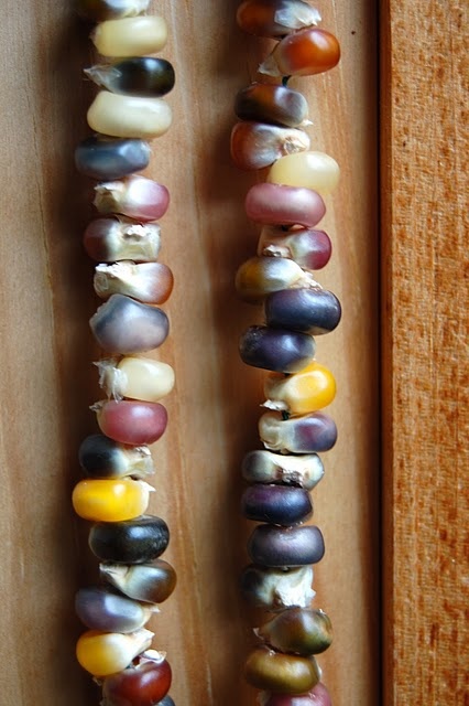 several different types of beads on a wooden surface next to another bead that has been made from shells