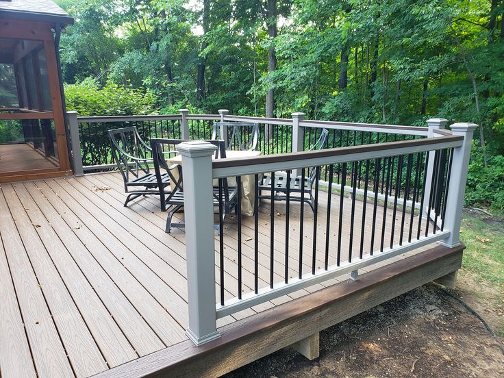 a wooden deck with chairs and table on it