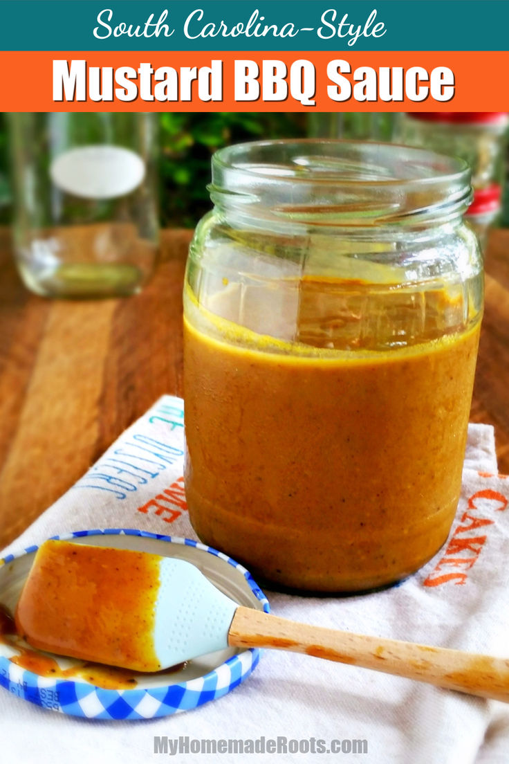 a jar filled with mustard sitting on top of a wooden table next to a spoon