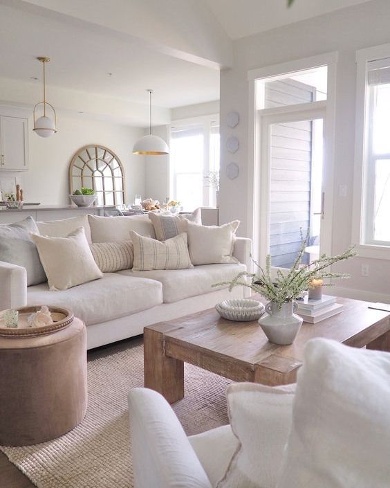 a living room filled with furniture and lots of white pillows on top of it's couches