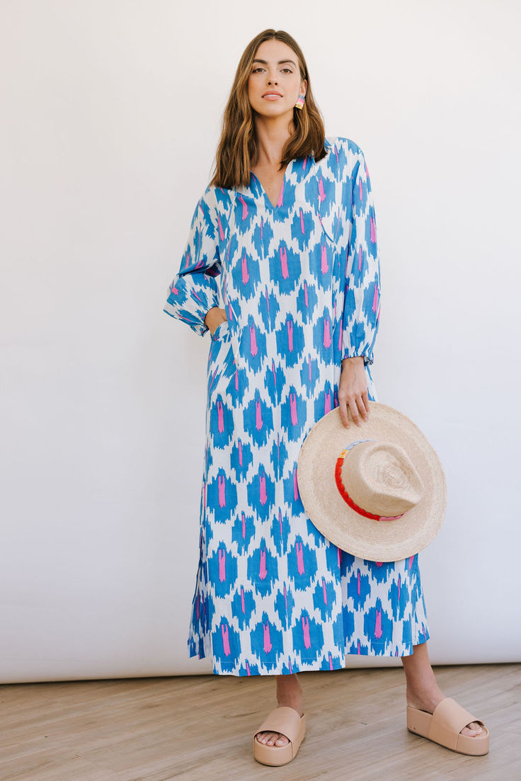 The Truman Ikat Sienna Dress fully embraces the colors of spring with a bold blue and vibrant pink in an exciting ikat print. The Sienna Dress is your classic summer kaftan (with pockets!). The unlined dress (but not see-through) has a perfectly cut side slit, and flattering plunge v-neck, making this a breezy dress for even the hottest of days. Dress runs oversized; size down if you want a more fitted look.  For dress length reference, the model is 5'10; the kaftan will hit at ankles on most. Summer Caftan, Summer Kaftan, Sienna Dress, Sarong Dress, Breezy Dress, Ikat Print, Maxi Styles, Bubble Sleeve, Caftan Dress