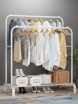 an ironing rack with clothes and shoes on it