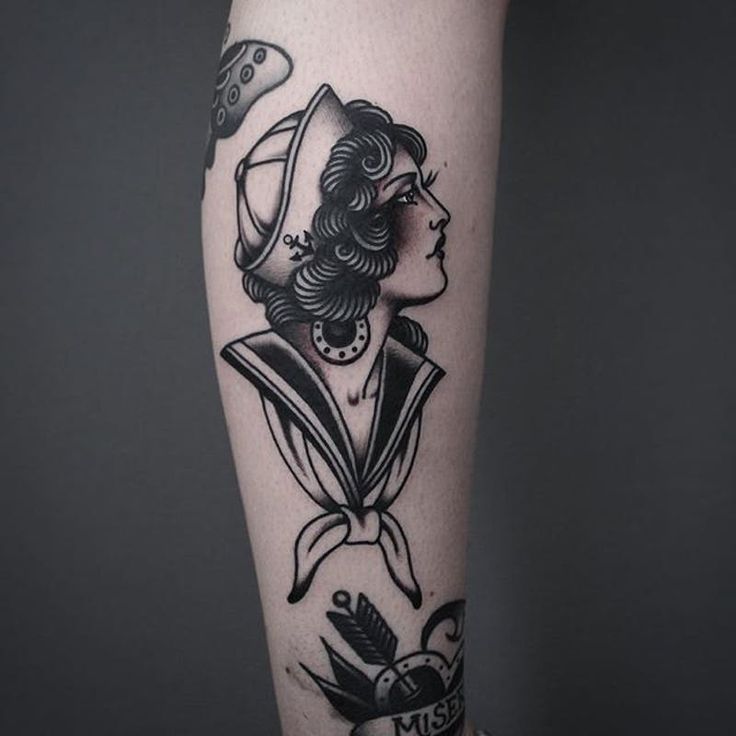 a woman's leg with a black and white tattoo on it