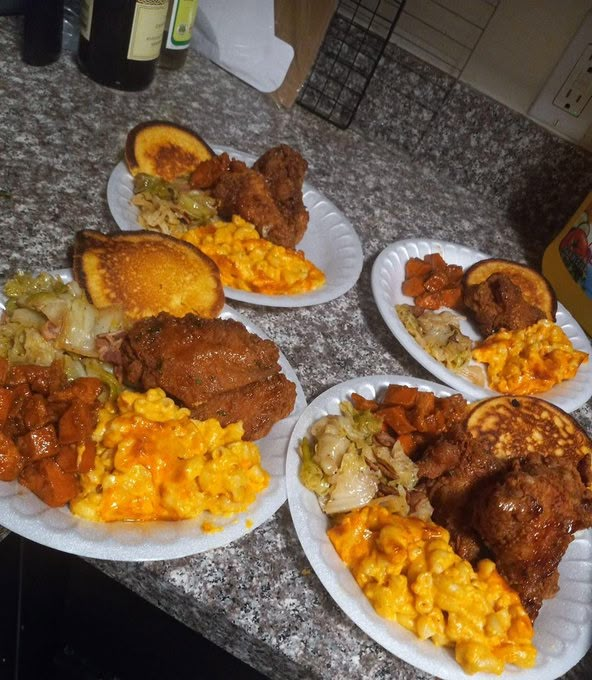 four paper plates filled with different types of food on top of a kitchen counter next to a bottle of wine