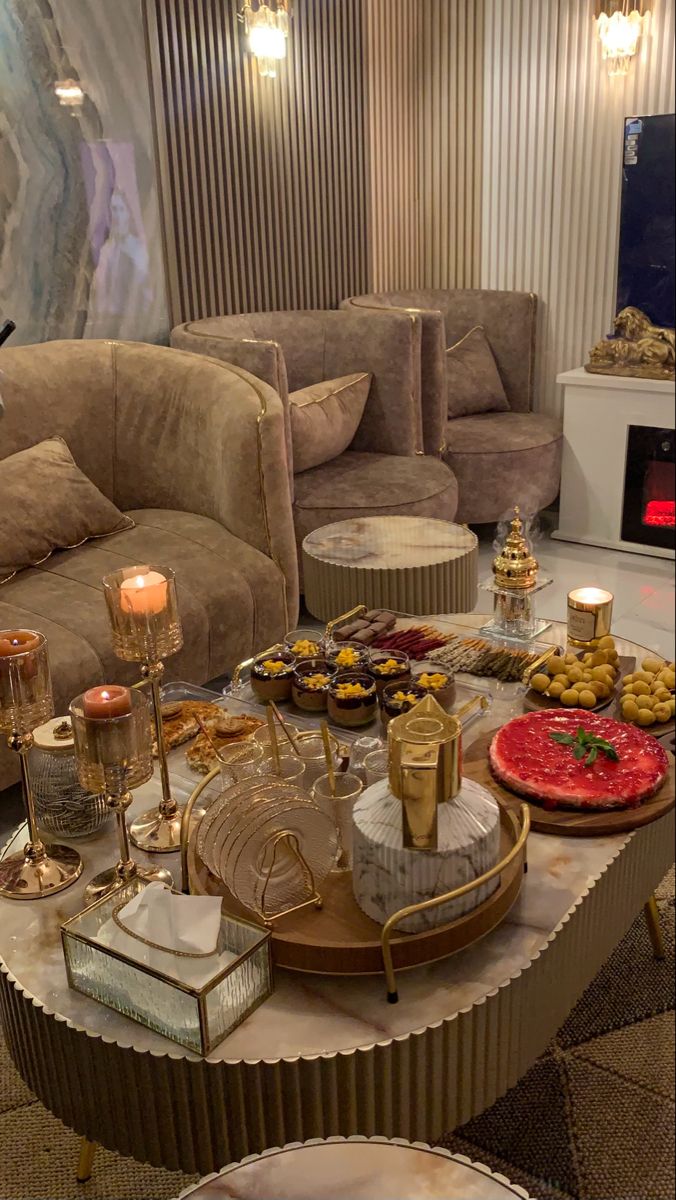 a living room filled with furniture and lots of food on top of a coffee table