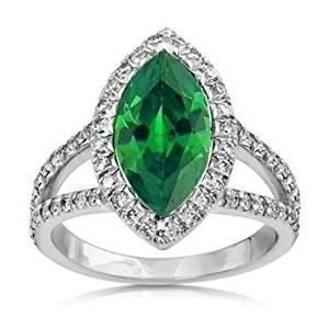 a green and white ring with diamonds on it's sides, set in 18k white gold