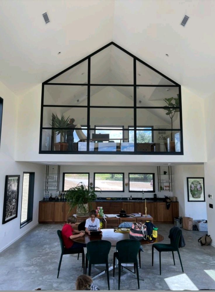 two people are sitting at a table in the middle of a room with high ceilings