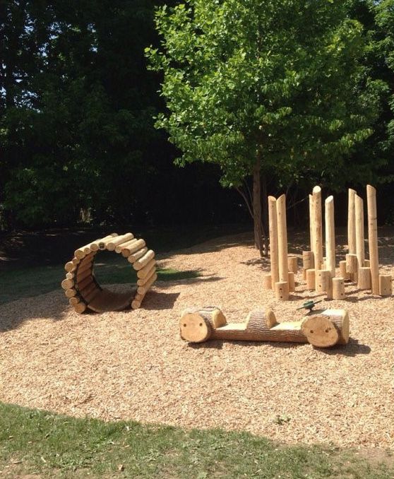 an outdoor play area with logs and climbing equipment