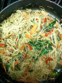 a pan filled with noodles and vegetables on top of a stove