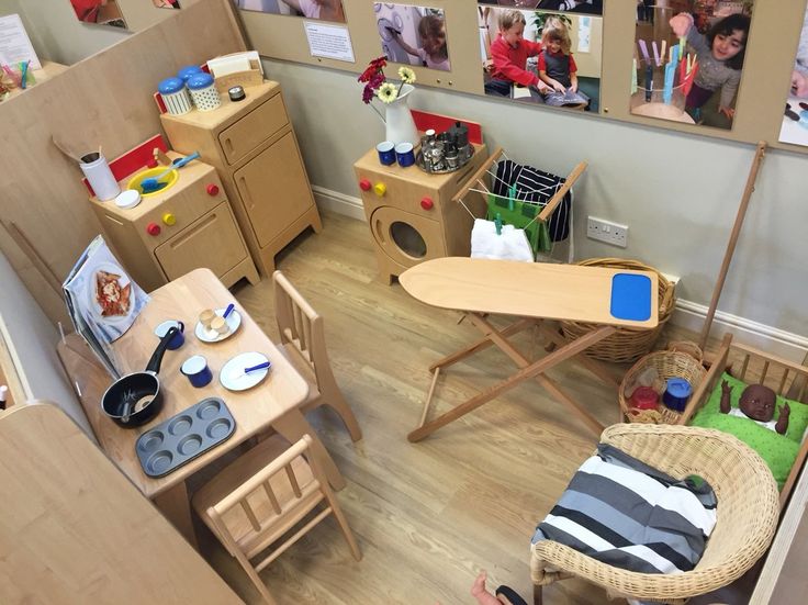 a child's playroom with wooden furniture and pictures on the wall