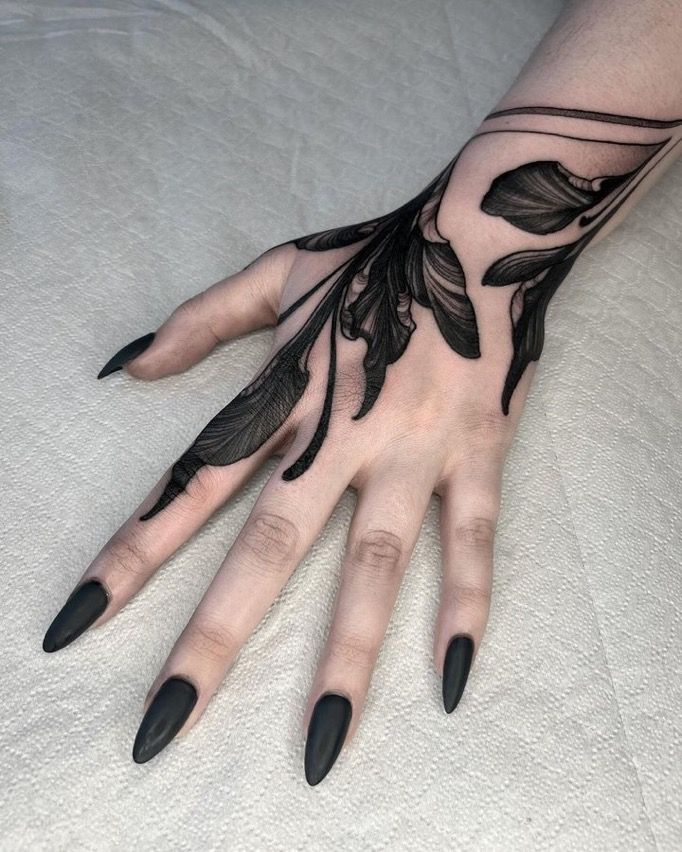 a woman's hand with black feathers on it