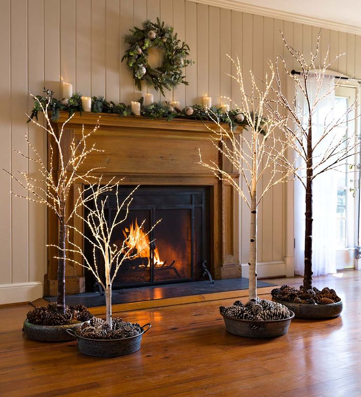 a living room filled with furniture and a fire place covered in fake tree's