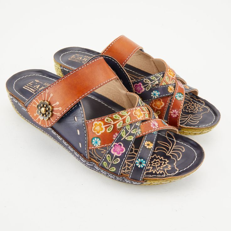 L'Artiste Style: Leigh French inspired, hand-painted leather slide sandal featuring unique color blocking and colorful floral embossing design. Heel Height (approximately): 1 1/4" leather-wrapped wedge, 1/2" platform. Features: -Round toe, hand-painted leather, floral embossed design, leather pieced wedge. -Hook-and-loop adjustable strap. -Synthetic leather lining. -Synthetic leather padded insole. -Polyurethane outsole. -Imported. Disclaimer: L'Artiste products are made with natural tanned leat Multicolor Open Toe Clogs For Summer, Multicolor Open Toe Clogs For Beach, Multicolor Sandals With Leather Footbed For Summer, Multicolor Leather Footbed Sandals For Summer, Multicolor Leather Sandals For Summer, Hand Painted Open Toe Leather Sandals, Hand Painted Leather Open Toe Sandals, Summer Multicolor Sandals With Leather Sole, Multicolor Sandals With Leather Sole For Summer