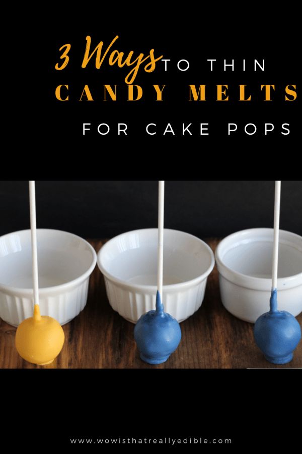 three white bowls with blue and yellow candy popss in them on a wooden table