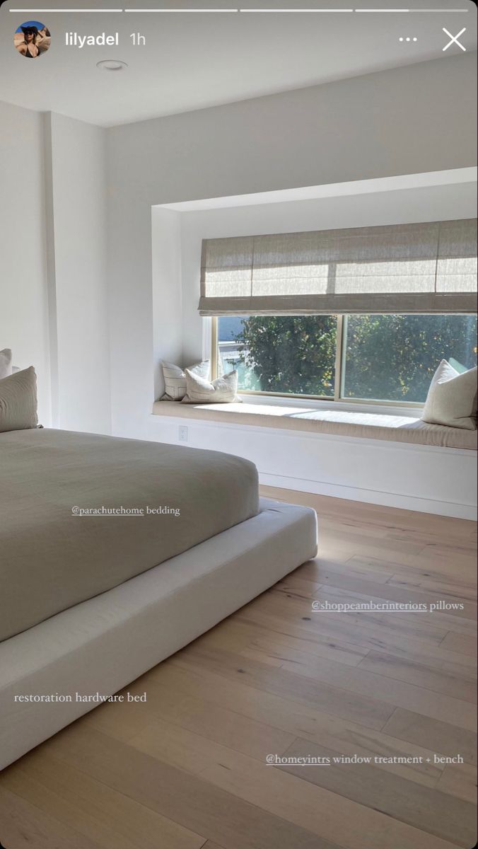 a bed sitting in the middle of a bedroom next to a window with blinds on it