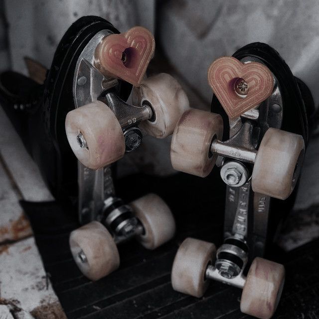 two skateboard wheels with hearts on them sitting next to each other in front of a wall