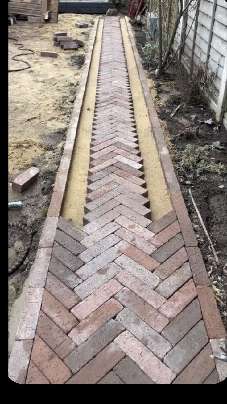 a brick walkway is being built in front of a house