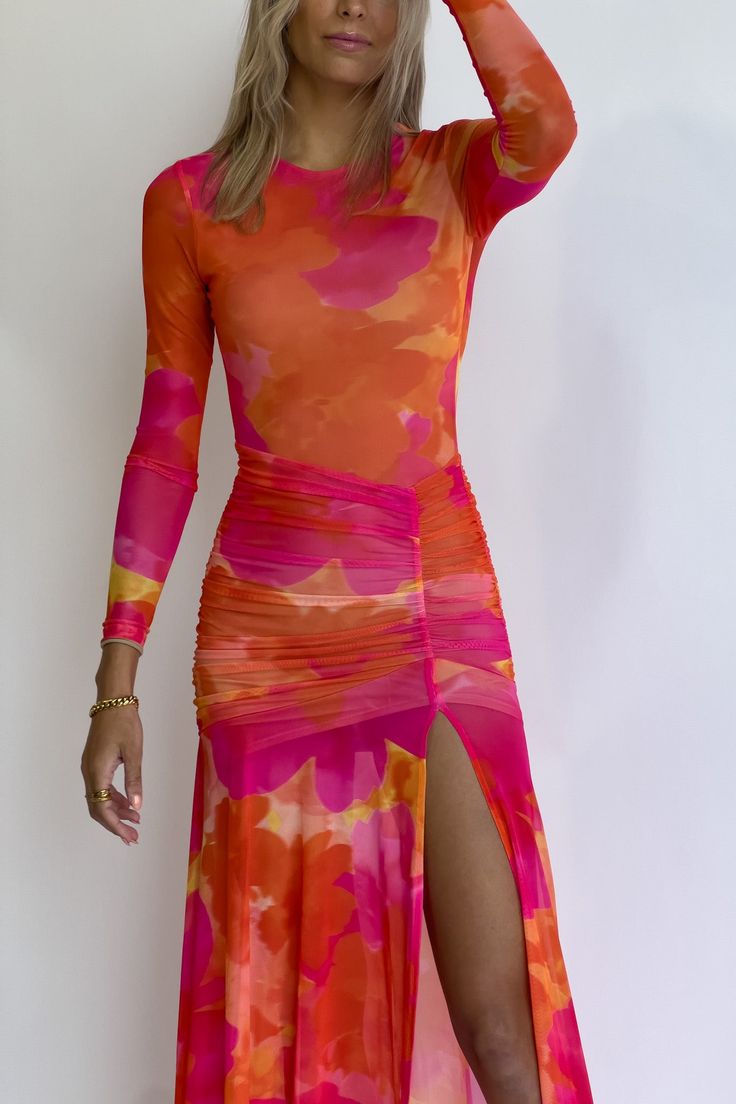 Complete with asymmetrical accents, the Olivia Maxi Dress in orange floral features vibrant hues of orange and pink, a rounded high neckline, and a stunning high slit detail. The Olivia Dress raises occasionwear standards and includes mesh, lightweight sleeves and a comfortable amount of stretch. Vibrant watercolor orange floral design Angled waistline and hem Lightweight mesh sleeves Asymmetrical ruching around hip High leg slit detail Secure neck button closure Maxi length Significant stretch Long Sleeve Wedding Guest Dresses, Watercolor Orange, Bright Color Dresses, Pink Evening Dress, Target Dress, Vibrant Watercolor, Purple Outfits, Bridal Party Dresses, Dress Orange