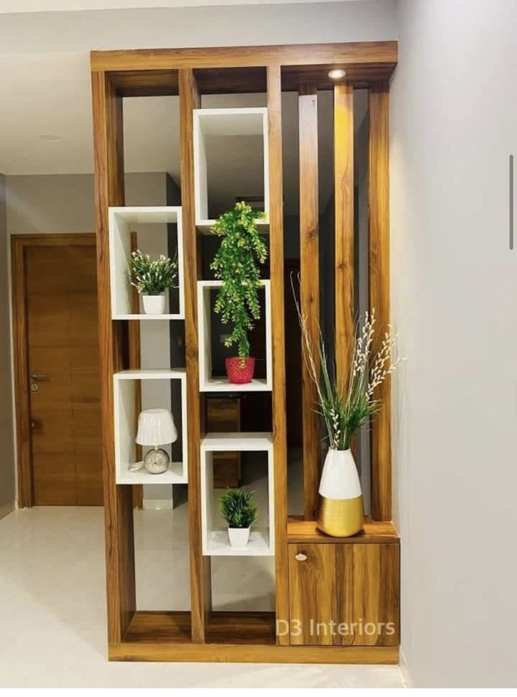 an empty room with some plants in the corner and shelves on the wall next to it