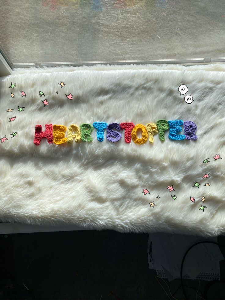 the word hope spelled out in multicolored letters on a white fur covered surface