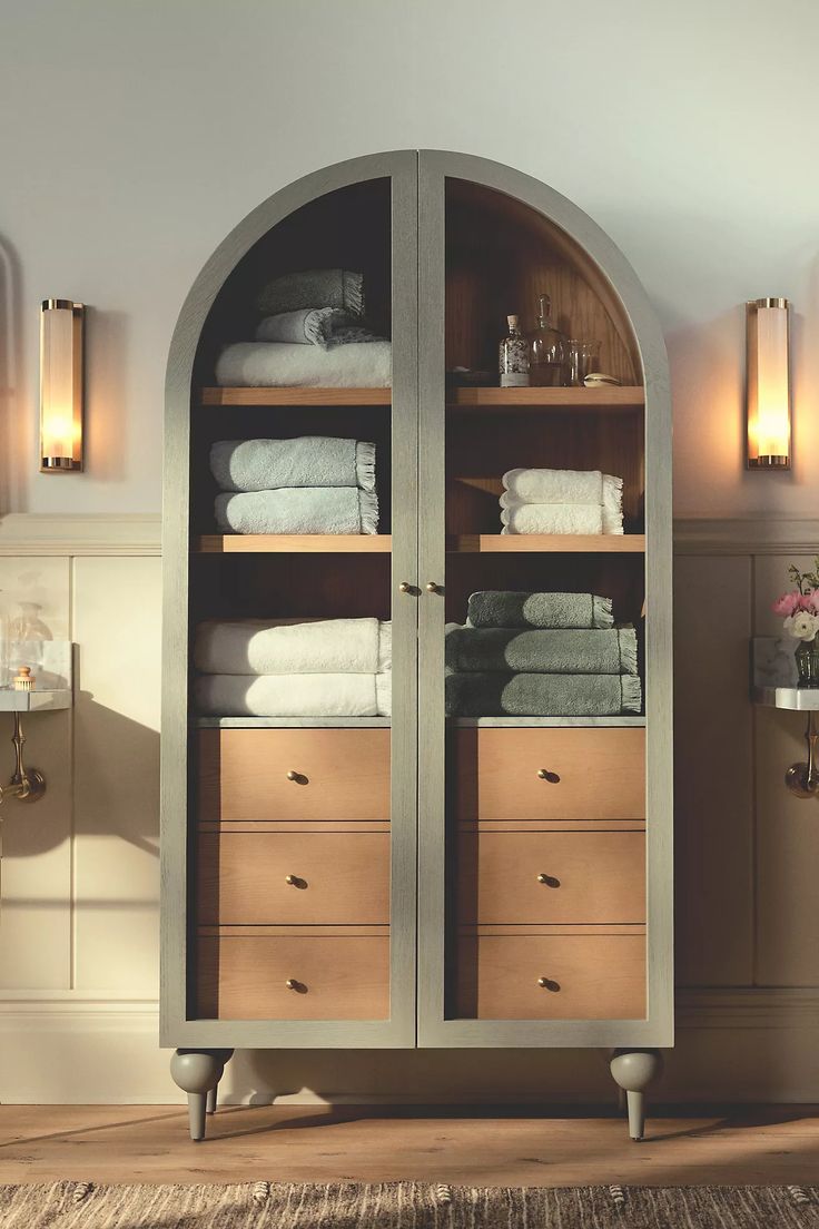 an arched cabinet with towels in it