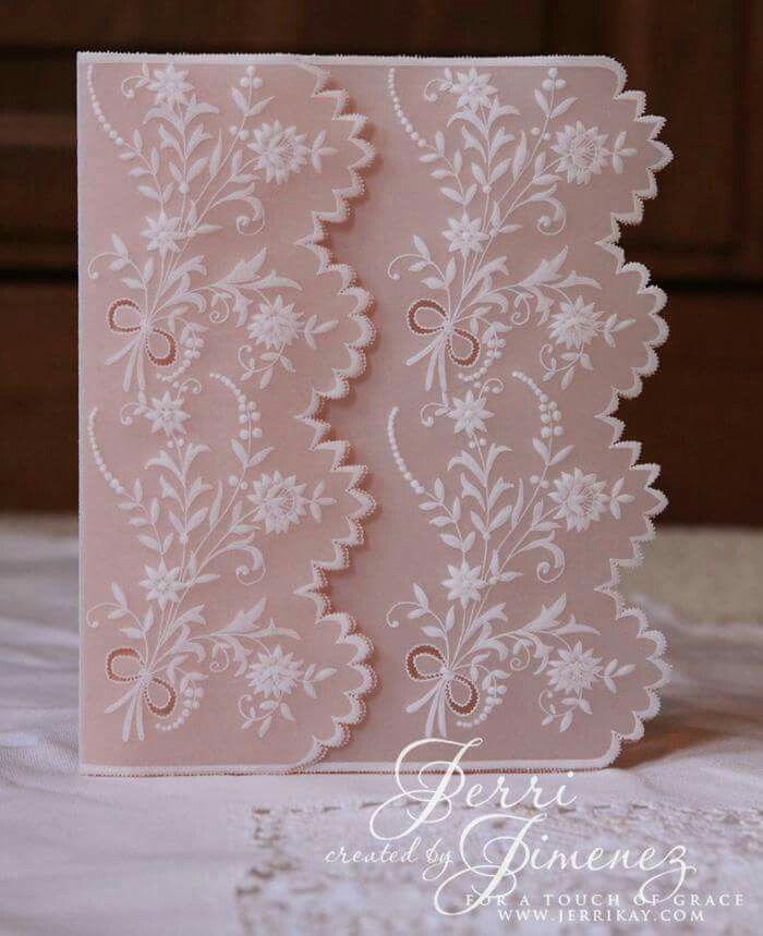 a close up of a card on a bed with lace and flowers in the background