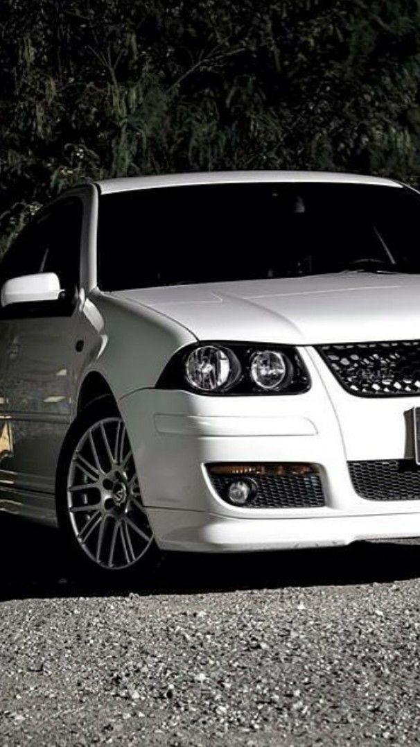 a white car parked in front of some trees