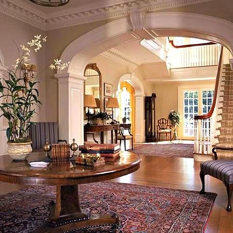 a living room filled with furniture and a large rug on top of a hard wood floor