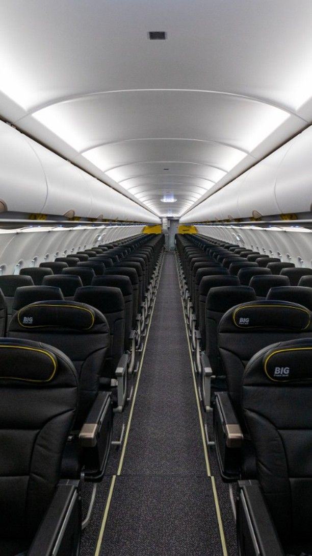 rows of empty seats in an airplane with lights on the ceiling and overhead lighting above them